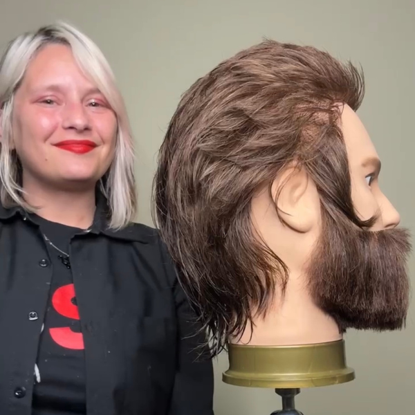 Stephanie Miller posing with a mannequin head with her competition-winning shag haircut.