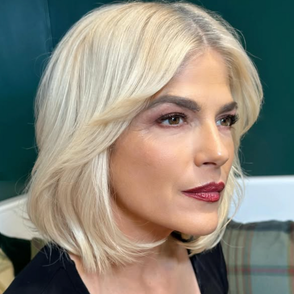 Woman over 50 with a blonde contour cut, styled in a sleek, layered bob with a center part.