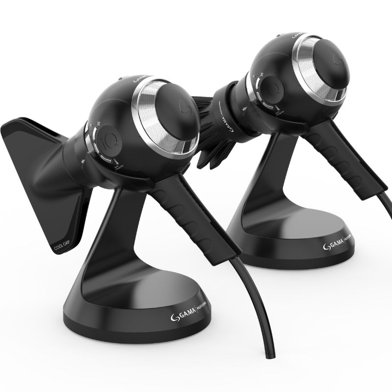 Two GA.MA Professional iQSFERA spherical hair dryers positioned on their Smart Holder stands, each fitted with different styling attachments to showcase versatility and ergonomic design.